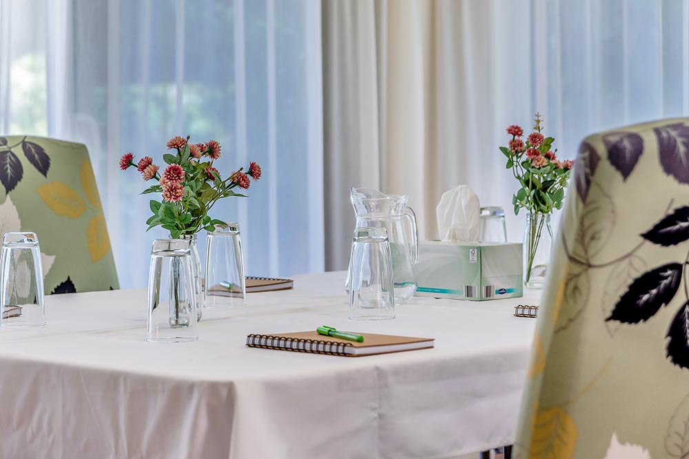 Beautiful table setting with pink flower arrangements in meeting room at Sarah's Circle in Mandurah, WA